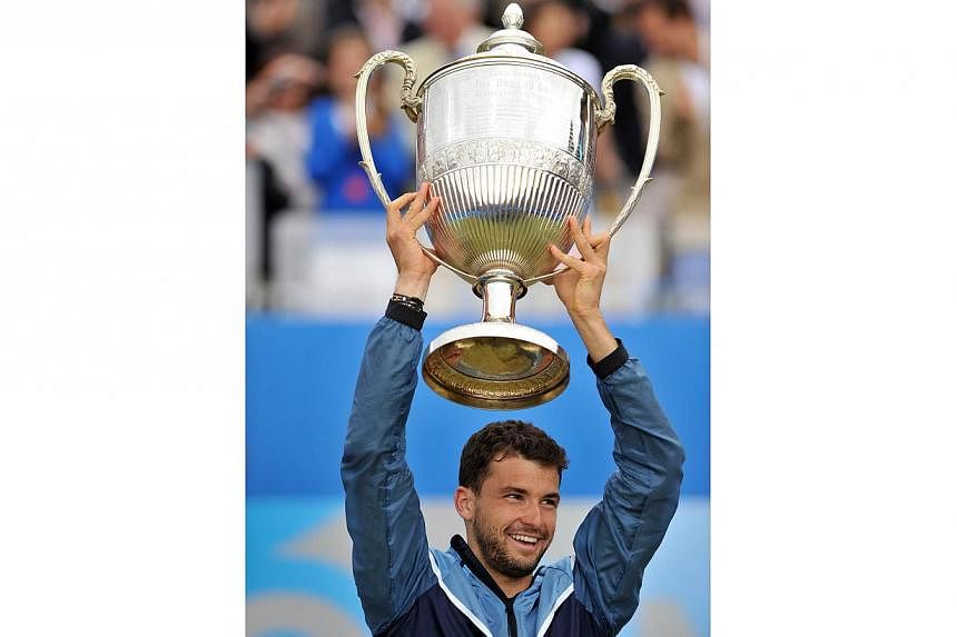 Bulgaria's Grigor Dimitrov celebrates with the trophy after victory over Spain's Feliciano Lopez in the final of the ATP Aegon Championships tennis tournament at The Queen's Club in west London, on June 15, 2014. &nbsp;-- PHOTO: AFP
