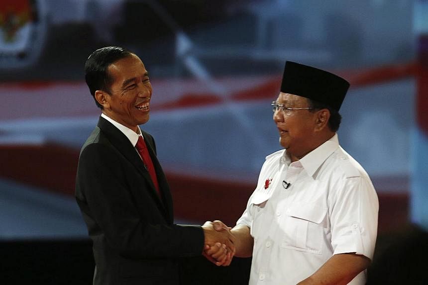 Indonesian presidential candidate Joko Widodo (left) shaking hands with his opponent Prabowo Subianto after a debate in Jakarta on June 15, 2014. Indonesia's two presidential candidates traded nationalist rhetoric on Sunday in a debate ahead of July'