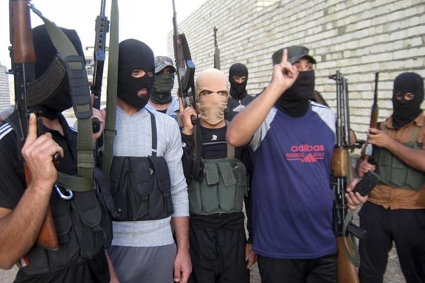 Masked Sunni gunmen pose for a photo during a patrol outside the city of Falluja on April 28, 2014. The New Straits Times newspaper reported on June 16, 2014 that at&nbsp;least 30 Malaysians have joined a militant group to fight in Iraq and Syria, an