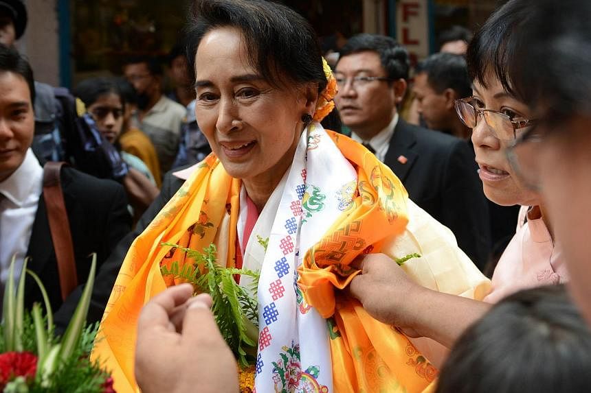 Myanmar opposition leader Aung San Suu Kyi is welcomed at a Buddhist monastery where she worked as an English teacher in 1973 in Kathmandu on June 16, 2014.&nbsp;Myanmar opposition leader Aung San Suu Kyi on Monday accused her country's election comm