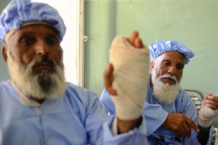 Afghan residents sit in a hospital ward after insurgents cut off their fingers in Herat on June 15, 2014.&nbsp;Afghan police hunted down and killed two Taleban insurgents who cut off the fingers of 11 elderly men who voted in the presidential electio