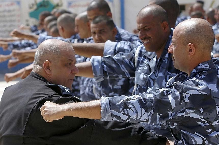 Newly-recruited Iraqi volunteers, wearing police force uniforms, take part in a training session on June 17, 2014, in the central Shi'ite Muslim city of Karbala.&nbsp;-- PHOTO: AFP