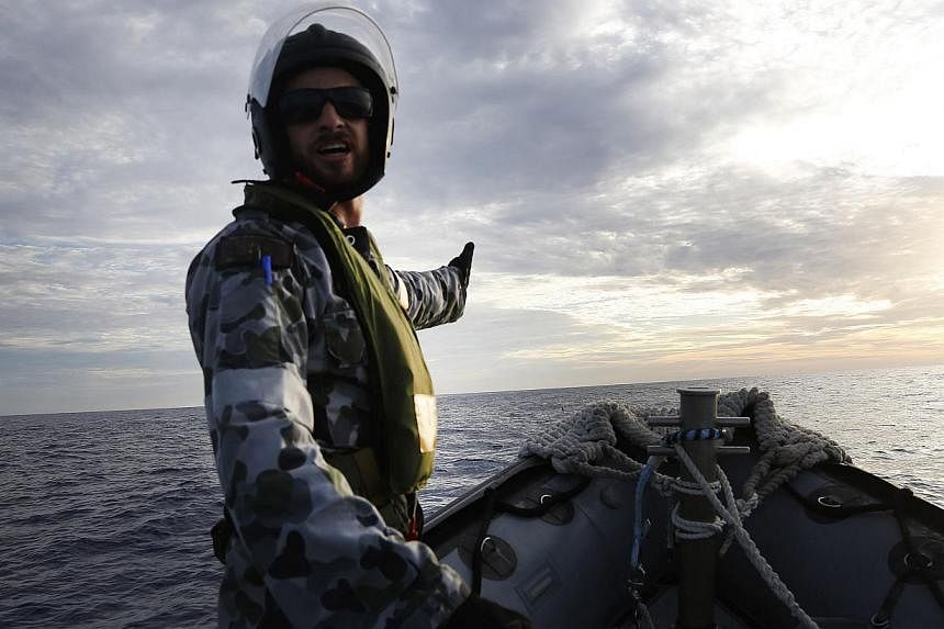 A Rigid Hull Inflatable Boat (RHIB) of HMAS Perth searching for debris from missing Malaysia Airlines flight MH370 in the southern Indian Ocean. -- PHOTO: AFP&nbsp;