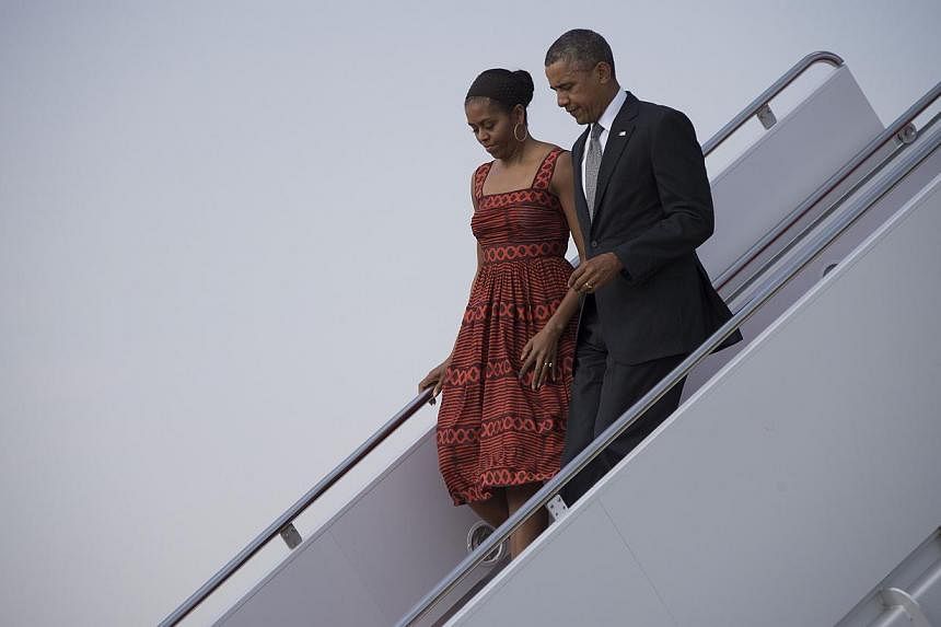 US President Barack Obama (right) and First Lady Michelle Obama walk off Air Force One at Joint Base Andrews, Maryland, on June 16, 2014. -- PHOTO: AFP