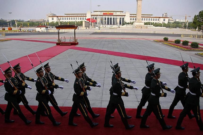 Soldiers from the honour guards of the Chinese People's Liberation Army (PLA) march in front of the Monument to the People's Heroes at Tiananmen Square in Beijing, on June 3, 2014. -- PHOTO: REUTERS