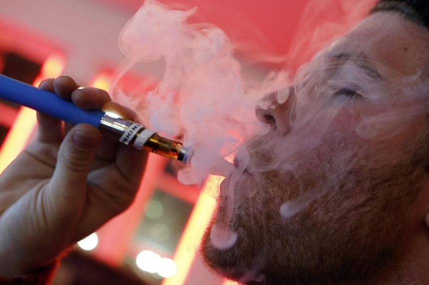 A customer puffs on an e-cigarette at the Henley Vaporium in New York City in this file photo taken on Dec 18, 2013. -- PHOTO: REUTERS