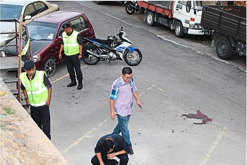 Police officers inspecting the scene of the shooting in Kajang. -- PHOTO: THE STAR/ASIA NEWS NETWORK