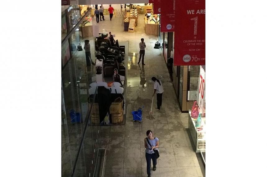 Staff cleaning up after sprinklers went off at JEM shopping mall.&nbsp;-- ST PHOTO: LIM YAOHUI