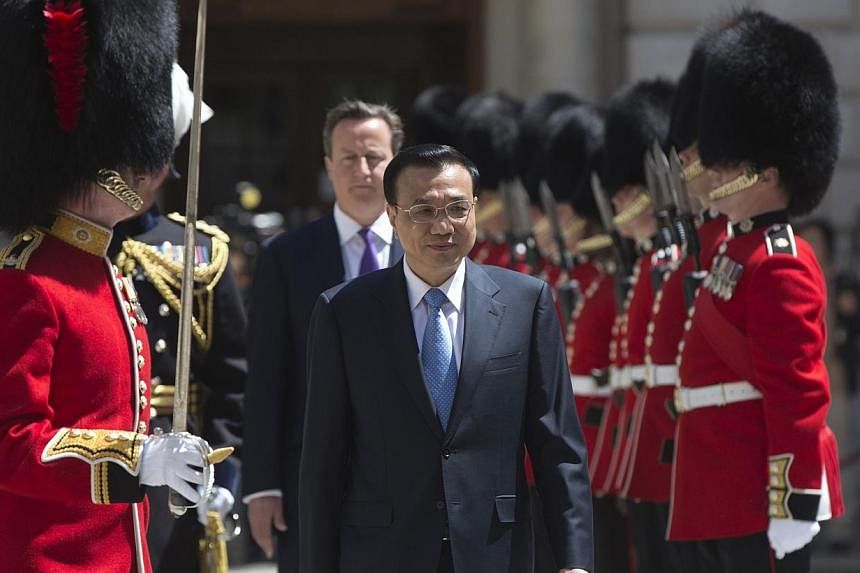 Chinese Premier Li Keqiang is followed by Britain's Prime Minister David Cameron as he inspects a Guard of Honour at the Treasury building in London on June 17, 2014.&nbsp;Mr Li said on Wednesday, June 18, 2014, that China's&nbsp;economy would not su
