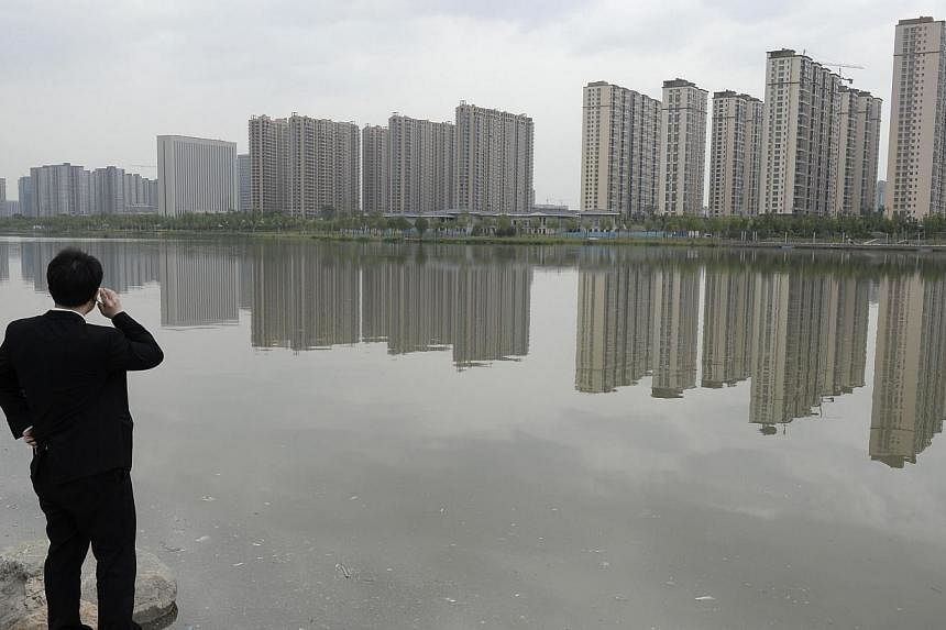 A man talks on his phone near a new residential compound in Taiyuan, Shanxi province on May 11, 2014.&nbsp;Optimism among Asia's top companies has hit its highest level in two years, amid positive political changes in the region and upbeat signs from