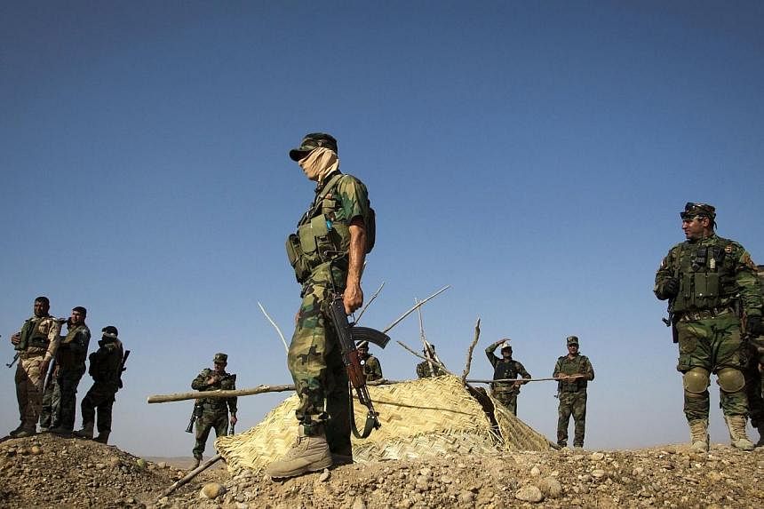 Members of Kurdish Peshmerga forces stand atop a hill during clashes with militants of the Islamic State of Iraq and the Levant (ISIL) jihadist group in Jalawla in the Diyala province on June 14, 2014. The United States is concerned with the situatio
