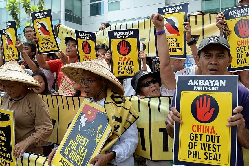 Protesters hold anti-China placards and shout slogans during a rally in front of the building housing Chinese consular offices in Manila on April 2, 2014. -- PHOTO: AFP&nbsp;