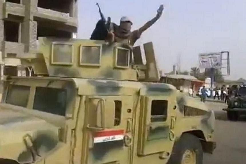 An image grab taken from a video uploaded on Youtube on June 17, 2014, allegedly shows militants from the Islamic State of Iraq and the Levant (ISIL) parading with an Iraqi army vehicle in the northern city of Baiji in the in Salaheddin province.&nbs