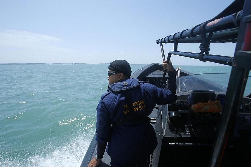 A Malaysia Maritime officer looks out into the sea during a search and rescue in Kuala Langat outside Kuala Lumpur, off Malaysia's western coast, on June 18, 2014.&nbsp;Twenty-seven people were missing on Wednesday and nine were confirmed dead after 