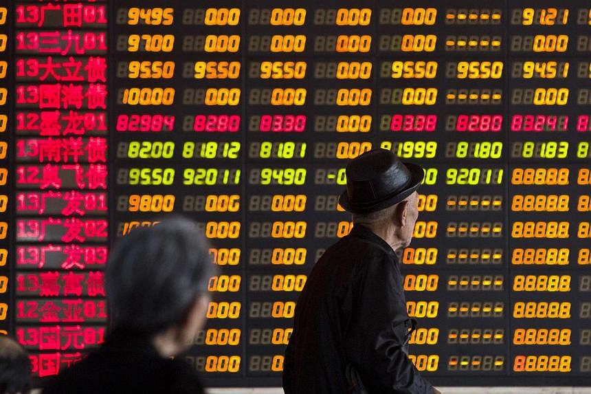 Caption: Investors look at information displayed on an electronic screen at a brokerage house in Shanghai, April 14, 2014. China shares were flat in light trade on Wednesday morning. -- PHOTO: REUTERS