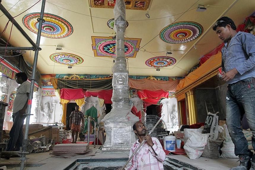 Workers seen inside the main hall of the Sri Veeramakaliamman temple along Serangoon Road during renovation and restoration works on May 30, 2014.&nbsp;Several roads and lanes are to be closed to vehicles in view of a consecration ceremony by the Sri