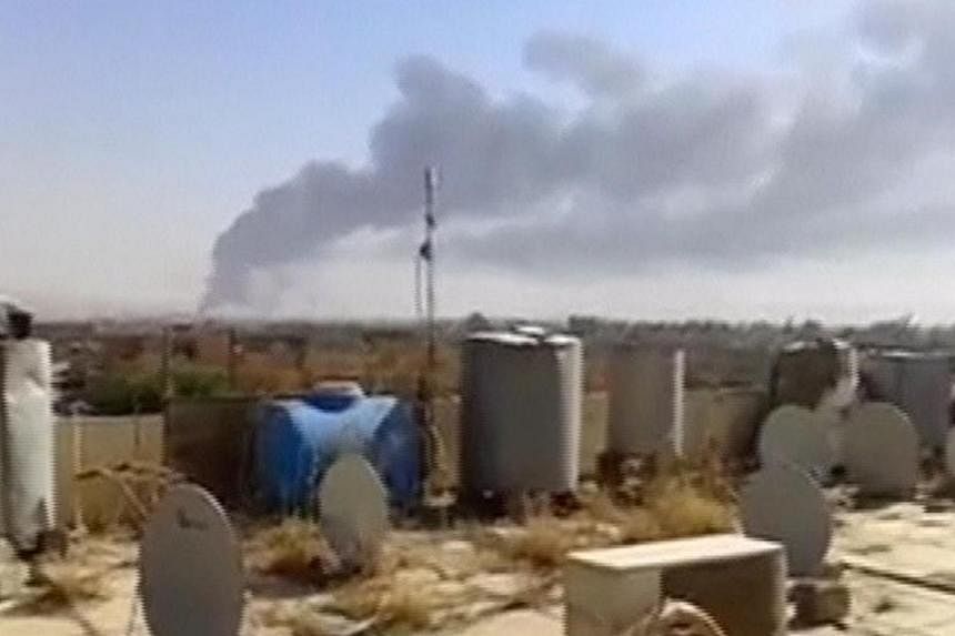 A large plume of smoke rises from what is said to be Baiji oil refinery in Baiji, northern Iraq, in this still image taken from an amateur video posted on a social media website June 18, 2014.&nbsp;Iraqi government forces regained full control on Thu