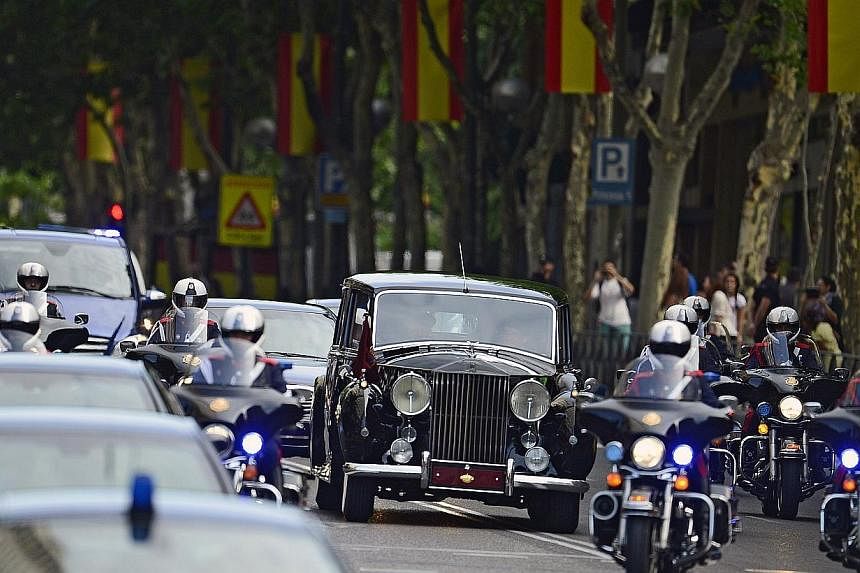Spain's King Felipe VI, Spain's Queen Letizia and Spanish Crown Princess of Asturias Leonor ride in a vehicle on the way from the Zarzuela Palace to the Congress of Deputies, Spain's lower House, in Madrid on June 19, 2014, for a swearing-in ceremony
