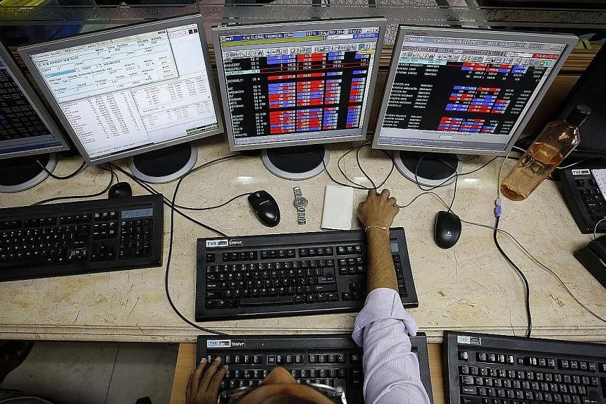A broker monitors share prices while trading at a brokerage firm in Mumbai on May 13, 2014.&nbsp;India's capital market regulator said the government should dilute its stake in listed public-sector companies over the next three years and cap it at 75
