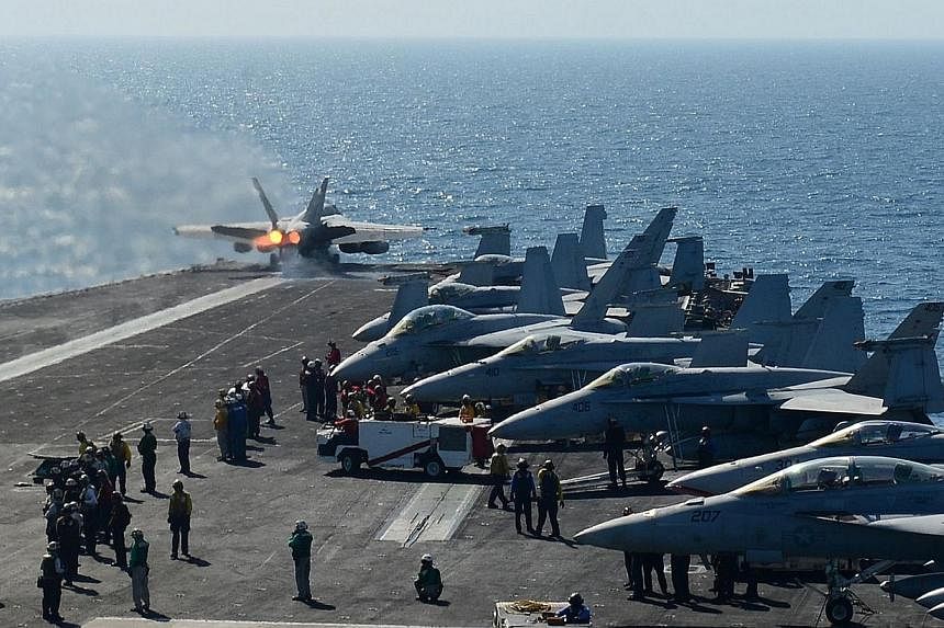 In this image released by the US Navy, a plane launches off the flight deck of the aircraft carrier USS George H.W. Bush during flight operatuions in the Arabian Gulf on June 17, 2014.&nbsp;The United States is flying F-18 attack aircraft launched fr