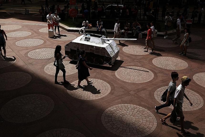 A mock tank, covered with photocopies of the "One country, two systems" white paper released earlier by Beijing on Hong Kong's control, is displayed by local artists to symbolise its threat to the city's autonomy, at a shopping district in Hong Kong 