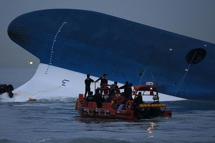 Maritime police search for missing passengers in front of the South Korean ferry Sewol which sank in the sea off Jindo on April 16, 2014.&nbsp;-- PHOTO: REUTERS