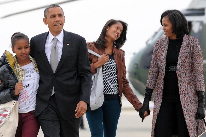 US President Barack Obama, First Lady Michelle Obama and their daughters Malia (right) and Sasha. The couple say in an interview with Parade magazine that they want their daughters to have the same experience they had of working minimum-wage jobs. &n