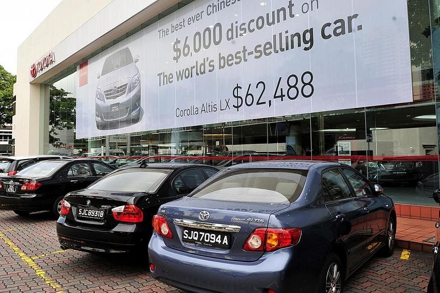 Toyota showroom at Leng Kee Complex. Car certificate of entitlement (COE) prices have tumbled by more than 20 per cent since April, but not all car prices have fallen in tandem. -- PHOTO: ST FILE