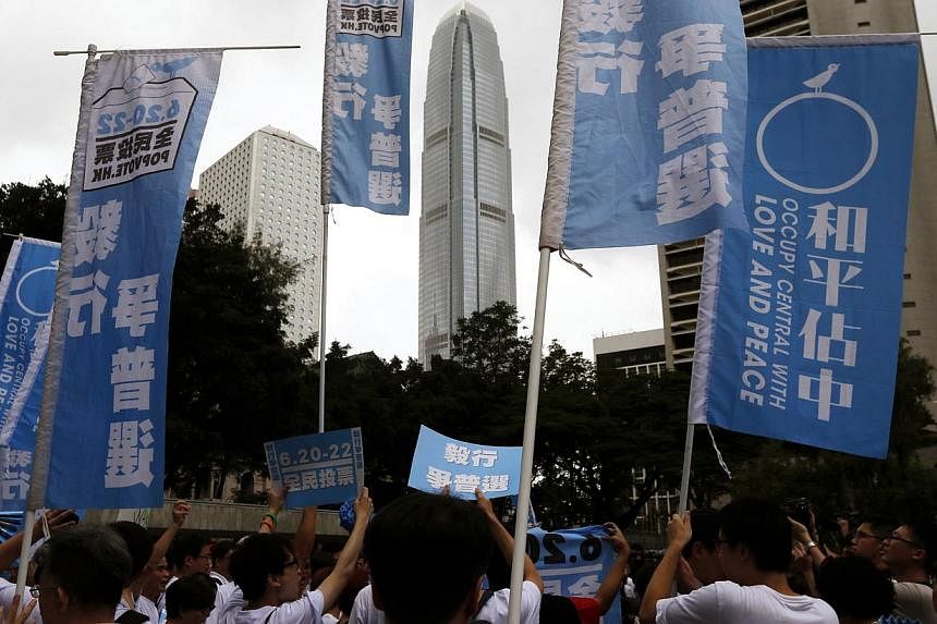 Supporters hold banners and placards at Hong Kong's financial Central district during a kick-off ceremony to urge people to vote in an unofficial referendum on June 20, 2014.&nbsp;More than 160,000 people took part in an unofficial Hong Kong vote on 