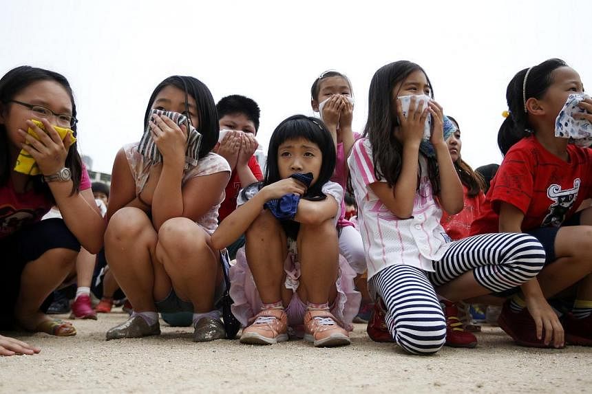 South Korean elementary school students take part in a evacuation exercise as a part of civil defence training in Seoul on June 20, 2014. -- PHOTO: REUTERS