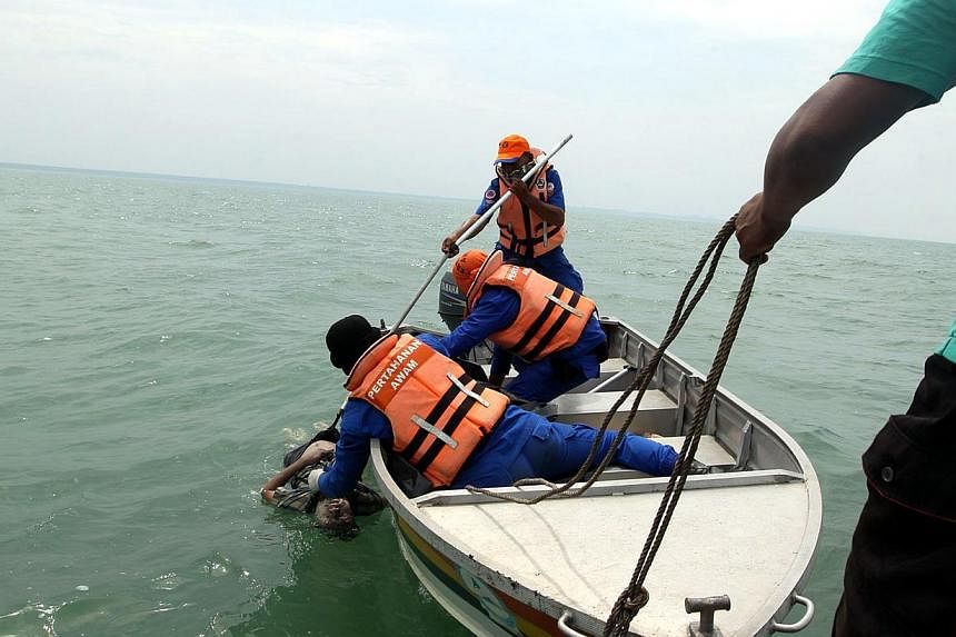 Rescuers pull bodies of victims of sunken boat at Kampung Kelamang Banting.&nbsp;Malaysian authorities said on Friday they have arrested two Indonesian men in connection with one of two boat accidents that have left 15 people dead and 27 others still
