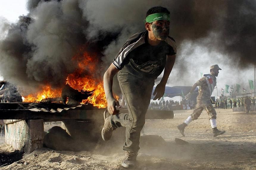 A Palestinian youth runs as he takes part in military-inspired exercises during a summer camp organised by the Islamist movement Hamas on June 19, 2014, in Rafah, southern Gaza Strip. -- PHOTO: AFP&nbsp;