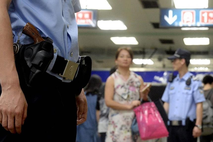 Armed policemen stand guard in a subway, after attackers ploughed two vehicles into a market and threw explosives, killing at least 31 people in Urumqi in northwest China's Xinjiang region, in Beijing on May 23, 2014. -- PHOTO: AFP