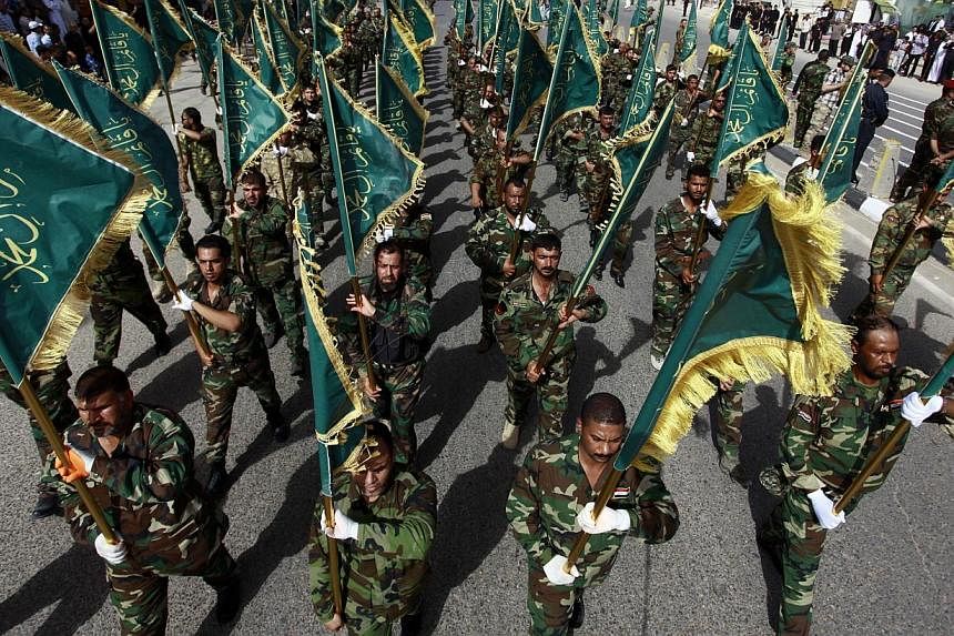 Iraqi security forces, loyal to Muslim Shi'ite cleric Moqtada al-Sadr take part in a military parade on June 21, 2014 in the shrine city of Najaf, in central Iraq.&nbsp;Washington readied a new diplomatic push to unite Iraq's fractious leaders on Sat
