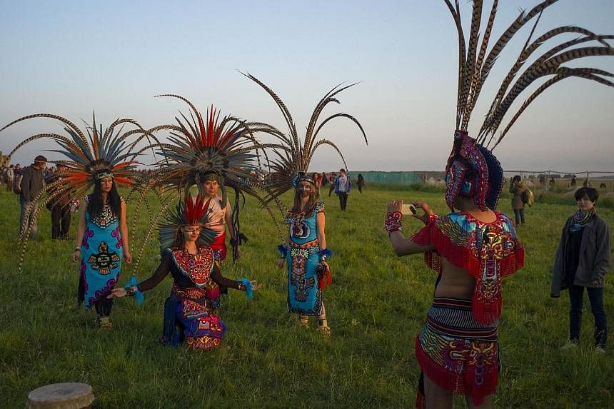 Revellers dressed in Aztec costume celebrate the summer solstice on Salisbury Plain in southern England on June 21, 2014. -- PHOTO: REUTERS