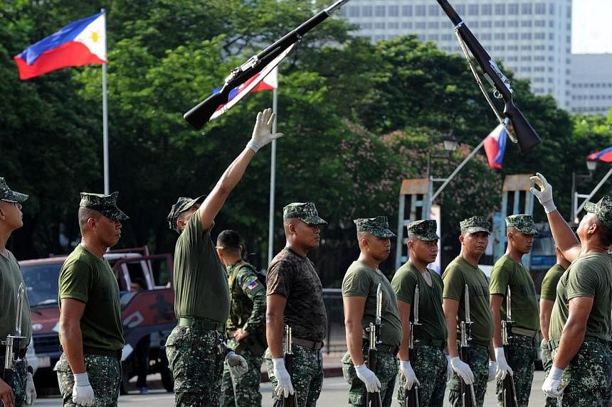 Soldiers toss their rifles into the air as members of the Philippine Army practice a ceremony on the eve of the country's Independence Day at Luneta Park in Manila on June 11, 2014. The Philippine army is getting a much-needed upgrade with the arriva