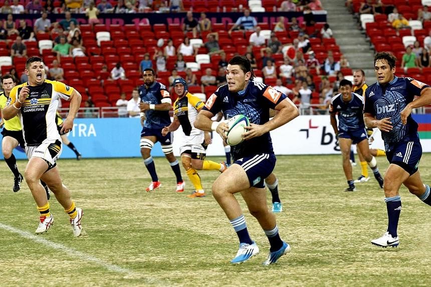 Jordan Manihera (centre) of The Blues carrying the ball against Australian team The Brumbies in the final match rugby World Club 10s. The Blues, from New Zealand, defeated The Brumbies 10-5 to win the tournament. -- ST PHOTO: CHEW SENG KIM
