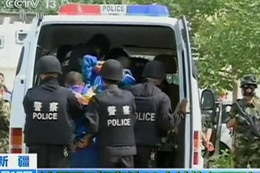 Riot policemen lead men who are about to be executed into a police van in this still image taken from video in an unknown location in the Xinjiang Uighur Autonomous Region, June 16, 2014. -- PHOTO: REUTERS&nbsp;
