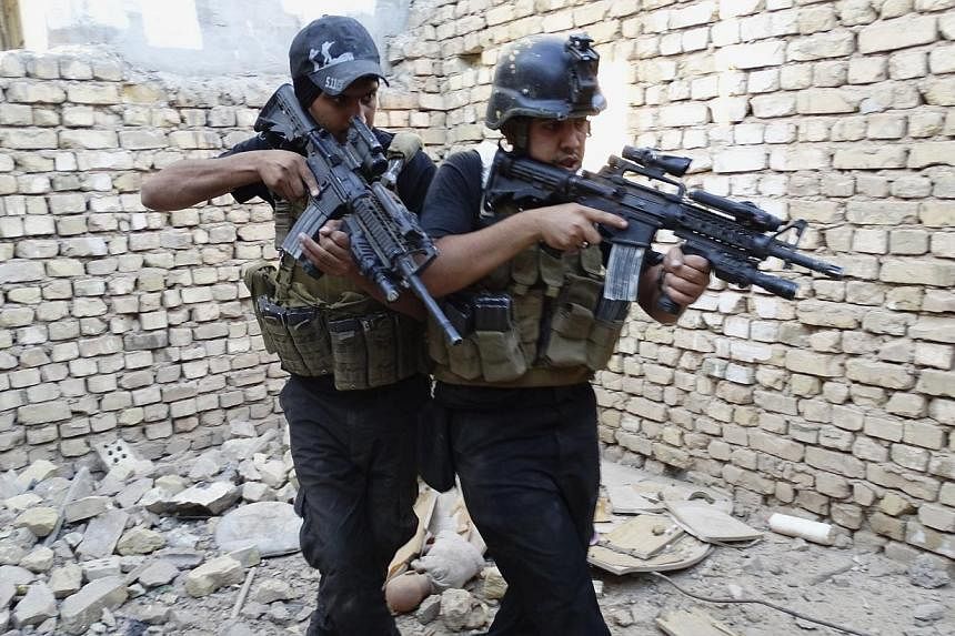 Members of the Iraqi Special Operations Forces take their positions during a patrol looking for militants of the Islamic State of Iraq and the Levant (ISIL), explosives and weapons in a neighbourhood in Ramadi, on June 11, 2014.&nbsp;Escalating viole