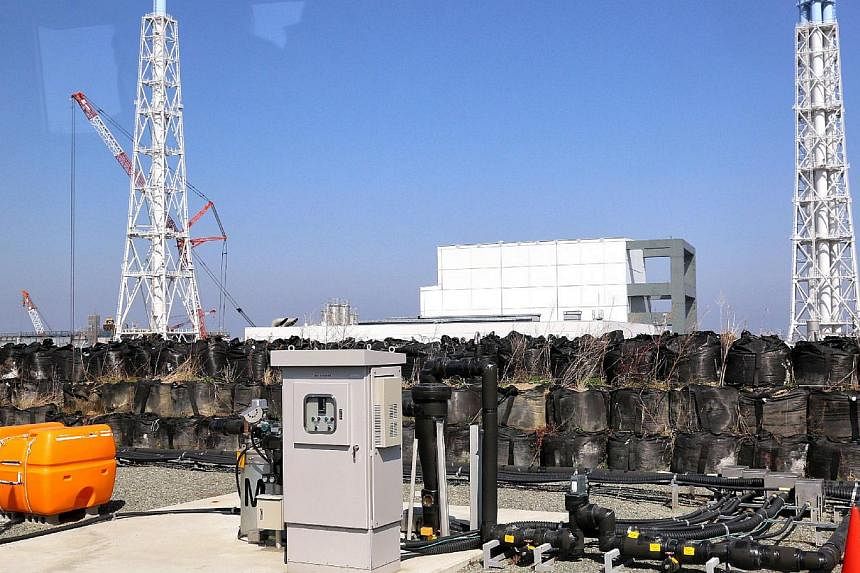 This picture taken on April 15, 2014, shows a facility to pump up underground water at the Tokyo Electric Power CO (Tepco) Fukushima Dai-ichi nuclear power plant at Okuma town in Fukushima prefecture, with the unit 3 and 4 reactor buildings behind.&n