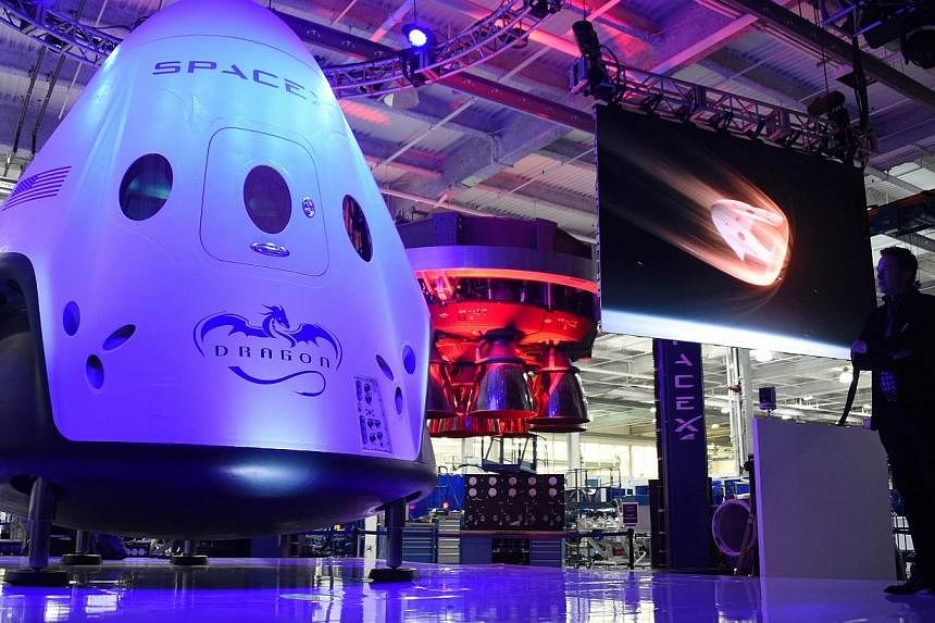 SpaceX CEO Elon Musk (right) unveils SpaceX's new seven-seat Dragon V2 spacecraft, at a press conference in Hawthorne, California, on May 29, 2014.&nbsp;Space Exploration Technologies, or SpaceX, on Saturday delayed the planned launch of a Falcon 9 r