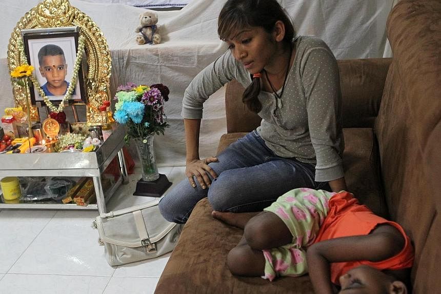 Madam Jaiyesthri Ramasamy sits next to a shrine with a photo of her three-year-old son Kryshan Nirmal Kumar, who died at Choa Chu Kang Christian cemetery when the private bus which took him there for a relative’s burial ran over him during an accid