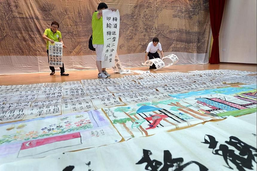 Works of calligraphy and Chinese brush paintings by residents and artists being displayed at the Braddell Heights Community Club. Fabric paintings depicting areas in Kampong Glam and colourful cubic-like clouds on show at the Kampong Glam Community C