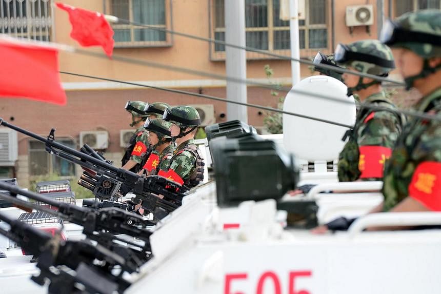 Security forces participating in a military drill in Hetian, northwest China's Xinjiang region on June 6, 2014. -- PHOTO: AFP