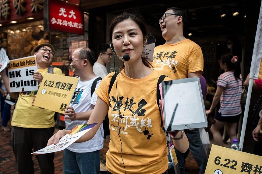Pro democracy activists distribute leaflets outside a polling station in Hong Kong on June 22, 2014. -- PHOTO: AFP