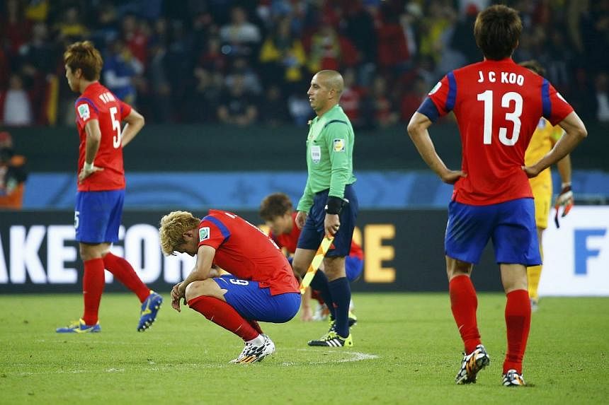 South Korea's Koo Ja-cheol, Son Heung-min and Kim Young-gwon (from right) react after losing their 2014 World Cup Group H soccer match against Algeria at the Beira Rio stadium in Porto Alegre on June 22, 2014. -- PHOTO: REUTERS