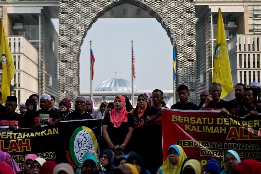 Malaysian Muslim activists wait for the verdict outside Malaysia's highest court in Putrajaya on June 23, 2014.&nbsp;Human rights group Amnesty International on Tuesday, June 24, 2014, condemned a Malaysian government ban on Christians using "Allah" 