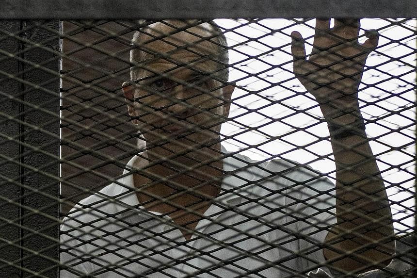 Al-Jazeera news channel's Australian journalist Peter Greste (C) listens to the verdict inside the defendants cage during his trial for allegedly supporting the Muslim Brotherhood on June 23, 2014 at the police institute near Cairo's Tora prison.&nbs