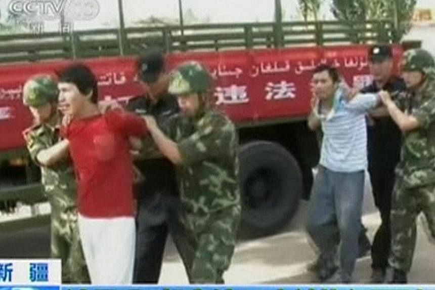 Men who are about to be executed are escorted by riot policemen outside in this still image taken from video in an unknown location in the Xinjiang Uighur Autonomous Region, on June 16, 2014.&nbsp;Chinese state television on Tuesday showed dramatic f