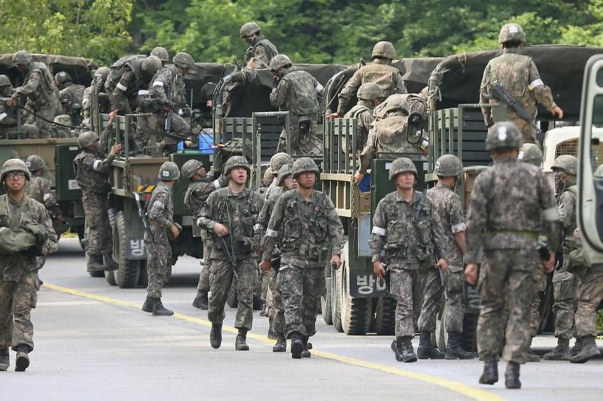 South Korean soldiers get in their military vehicles as they take part in a search and arrest operation in Goseong on June 23, 2014. A deadly shooting spree by a South Korean military serviceman has once again raised questions over the wisdom of depl